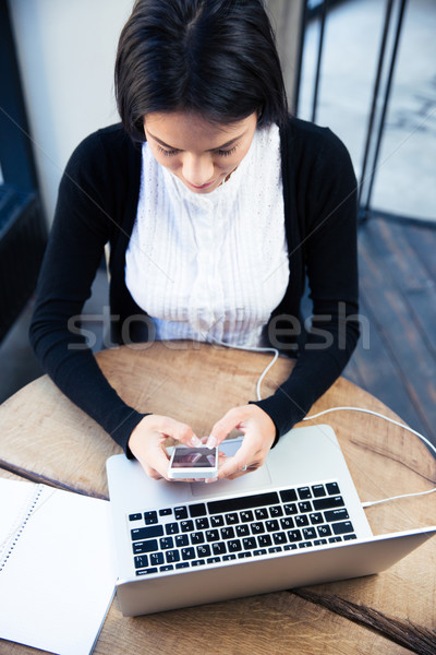 Businesswoman using smartphone in cafe Stock photo © deandrobot