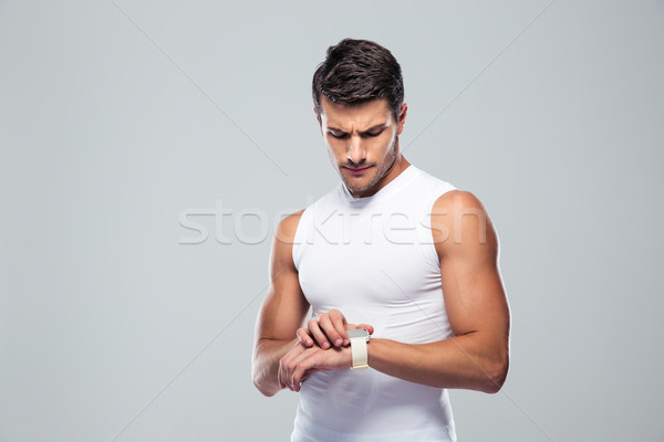 Handsome sports man using smart watch Stock photo © deandrobot