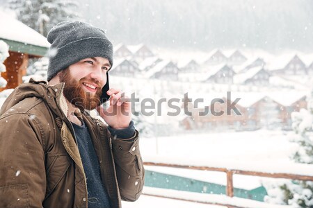 [[stock_photo]]: Souriant · homme · parler · téléphone · portable · extérieur · météorologiques