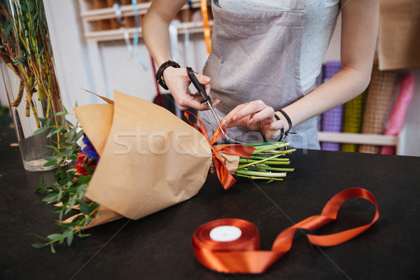 Nő virágárus készít íj vörös szalag virágcsokor Stock fotó © deandrobot