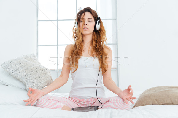 Nő meditál ágy otthon számítógép zene Stock fotó © deandrobot