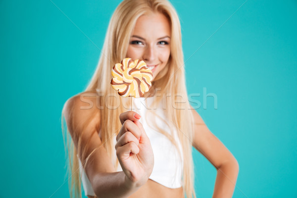 Portrait of a pretty woman with long hair showing lollipop Stock photo © deandrobot