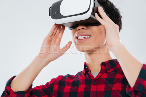 Asian man wearing virtual reality device Stock photo © deandrobot