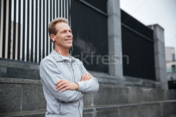 Runner standing with arms crossed on the street Stock photo © deandrobot