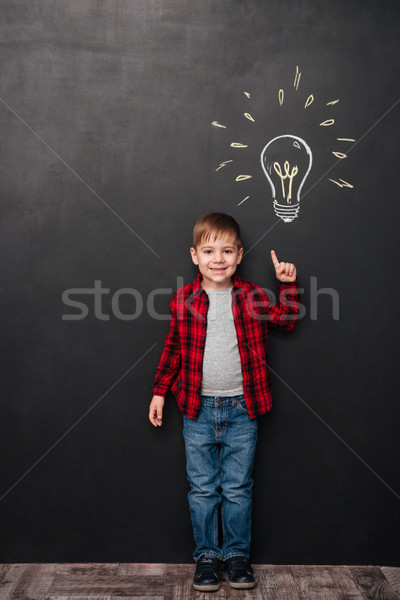 Little boy pointing up and having idea over chalkboard background Stock photo © deandrobot