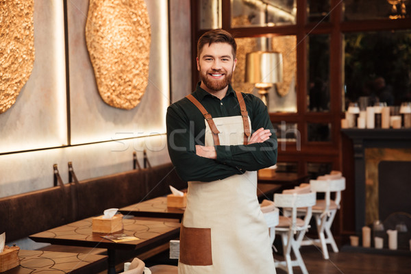 Amazing young man waiter standing in cafe. Stock photo © deandrobot