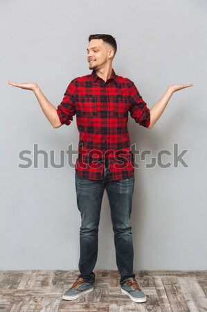 Vertical image of Smiling man pointing at camera Stock photo © deandrobot