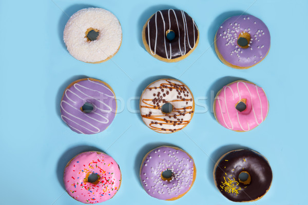 Colorful sweeties donuts over blue table background. Stock photo © deandrobot