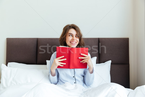 Ritratto felice donna sorridente pigiama libro Foto d'archivio © deandrobot