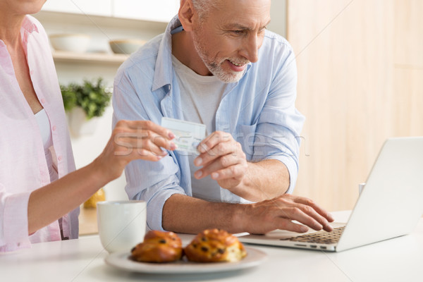 Heureux maturité affectueux couple famille utilisant un ordinateur portable [[stock_photo]] © deandrobot