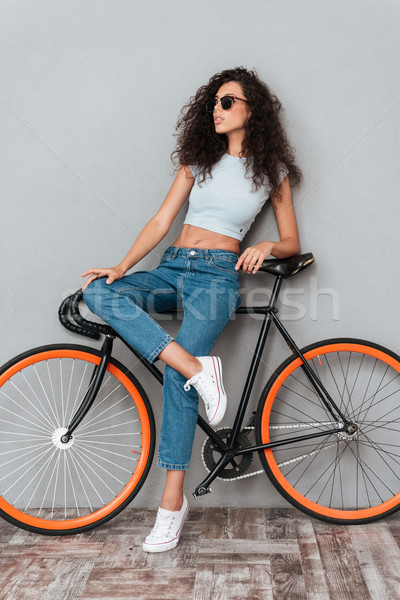 Full length picture of pretty curly woman in sunglasses Stock photo © deandrobot
