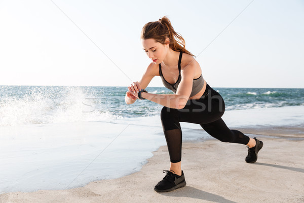 Portrait of young healthy sport woman checking time while doing  Stock photo © deandrobot