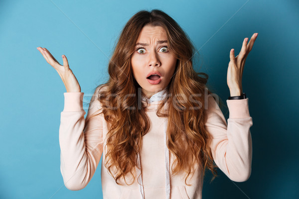 Displeased shocked young woman standing isolated Stock photo © deandrobot