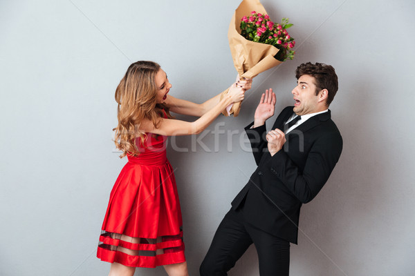 Stock photo: Portrait of a mad woman beating up a man