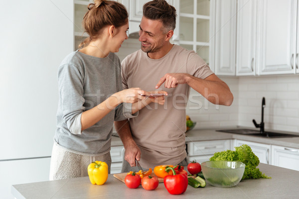 Portrait of a young loving couple cooking salad together Stock photo © deandrobot