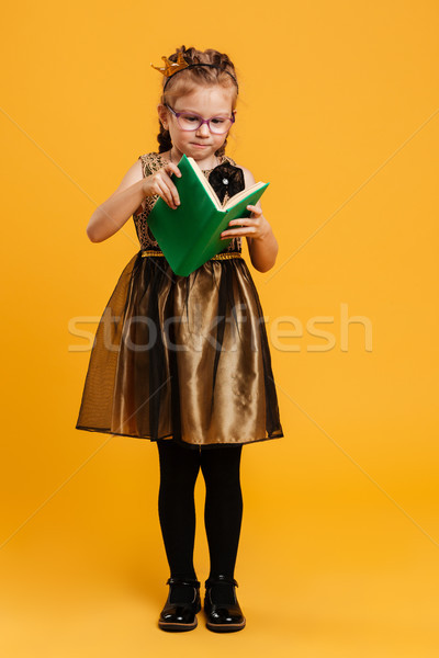 Pretty girl child wearing princess crown reading book. Stock photo © deandrobot