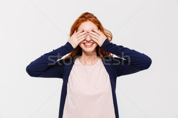 Happy young redhead lady covering eyes with hands. Stock photo © deandrobot