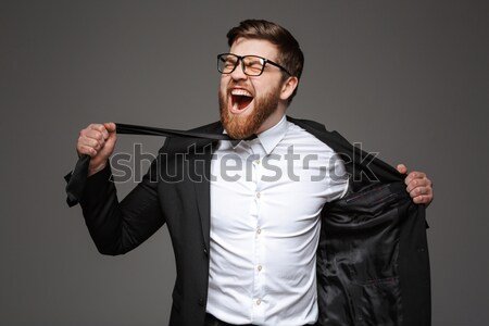 Portrait of a crazy young businessman dressed in suit Stock photo © deandrobot