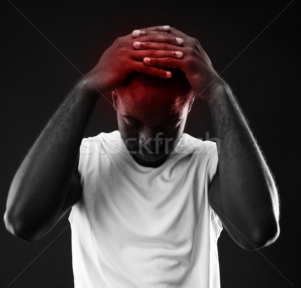 Pensive african man touching his head over black background Stock photo © deandrobot
