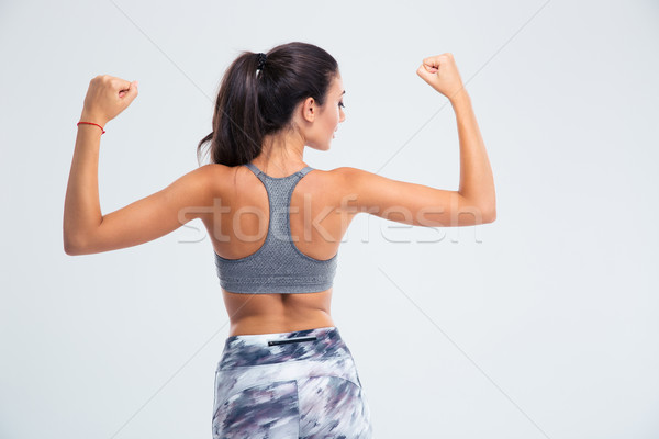 Back view portrait of a fitness woman showing her biceps  Stock photo © deandrobot