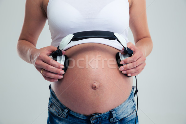 Foto stock: Mulher · grávida · fones · de · ouvido · barriga · isolado · branco