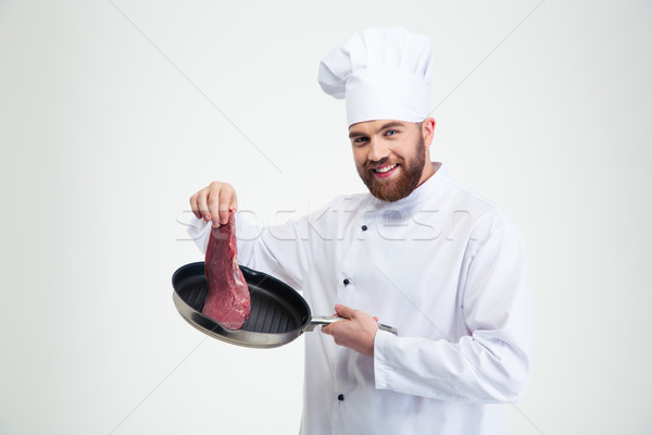 Smiling chef cook holding pan with fresh meat  Stock photo © deandrobot
