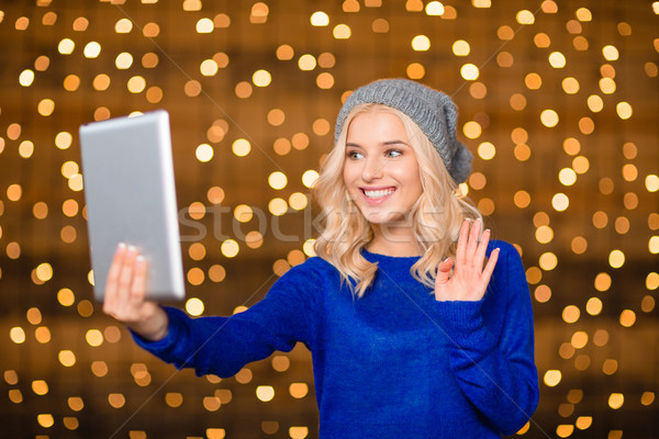 Stock photo: Happy woman doing video call on tablet computer