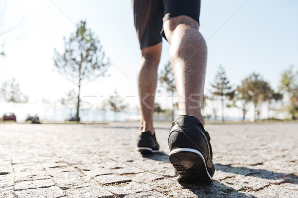 Legs of male sportsman running in the city Stock photo © deandrobot