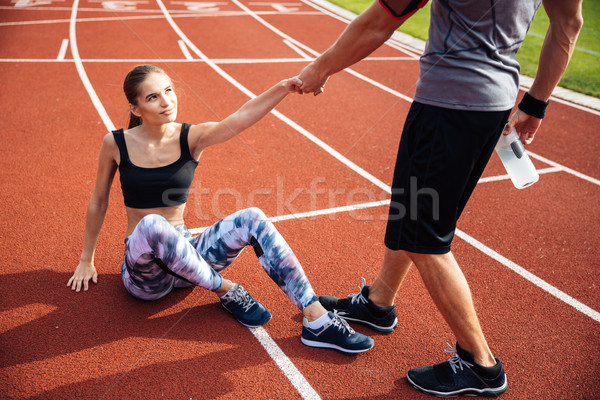 Image fitness homme une bouteille d'eau aider jeune fille [[stock_photo]] © deandrobot