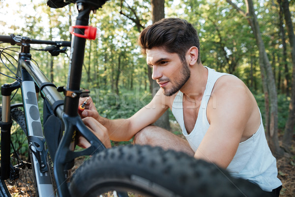 Close up man repairing a bicycle in forest Stock photo © deandrobot