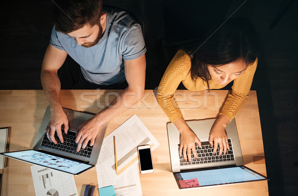 Top view of two colleagues working at night in office Stock photo © deandrobot