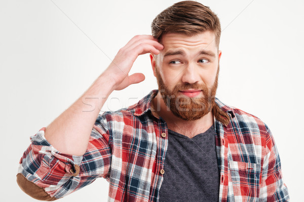 Thoughtful bearded man in checkered shirt touching his face Stock photo © deandrobot