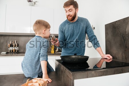 Happy father cooking at kitchen with his little cute son Stock photo © deandrobot