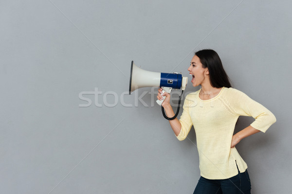 Vista lateral enojado mujer gritando megáfono suéter Foto stock © deandrobot