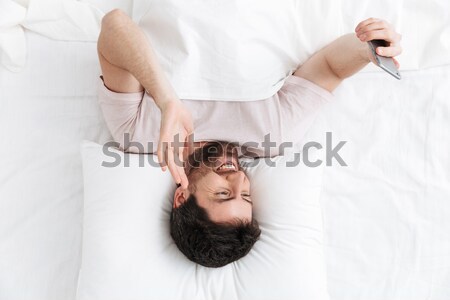 Woman sleeping in a hotel bed with a mobile phone Stock photo © deandrobot