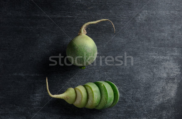Cut radish over dark background Stock photo © deandrobot