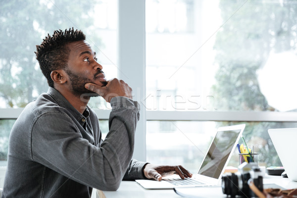 Handsome thinking serious young man sitting in office coworking Stock photo © deandrobot