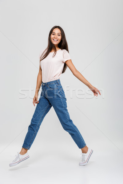 Full length portrait of a casual young asian woman jumping Stock photo © deandrobot