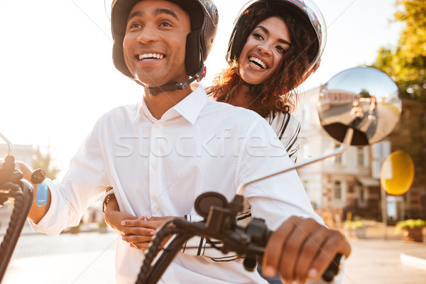 Image of Happy african couple rides on modern motorbike Stock photo © deandrobot