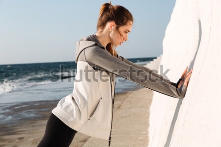 Photo of young slim sport woman doing push-ups while standing ne Stock photo © deandrobot