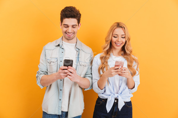 Photo of positive people man and woman smiling while both using  Stock photo © deandrobot