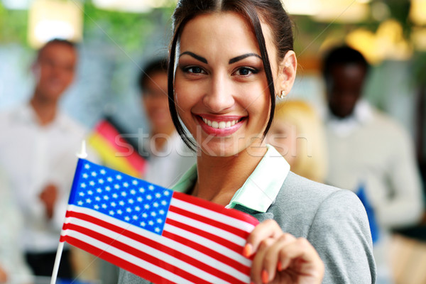 Stock photo: Happy businesswoman holding flag of USA in front of colleagues