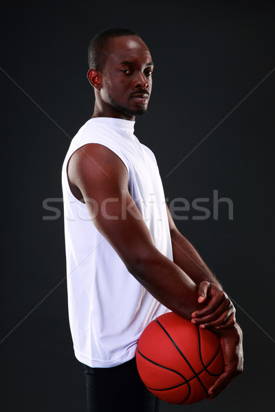 Young african american basketball player over black background Stock photo © deandrobot