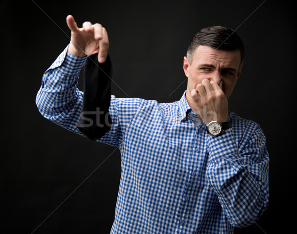 Man holding smelly socks and clogged nose Stock photo © deandrobot