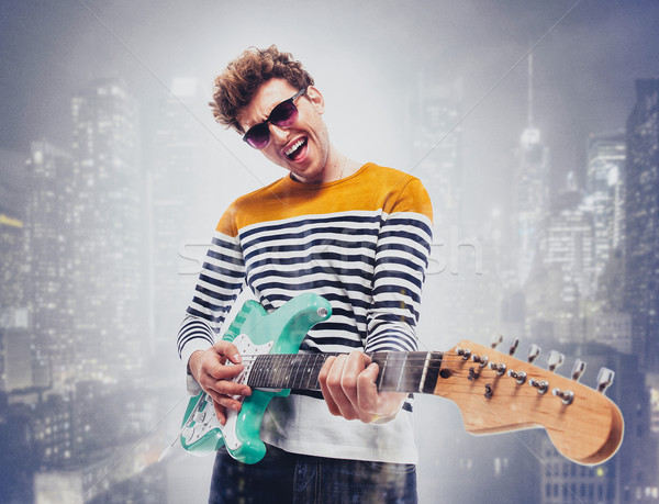 Double exposure of a city and happy man playing guitar Stock photo © deandrobot
