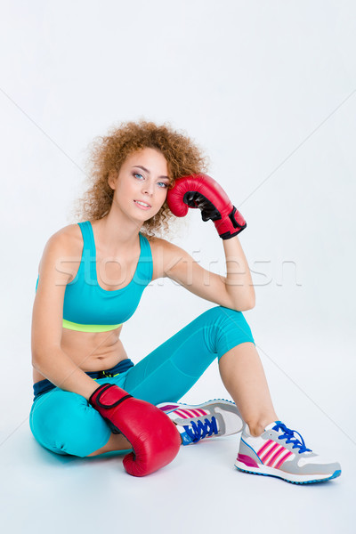 Sports woman in boxing gloves sitting on the floor Stock photo © deandrobot