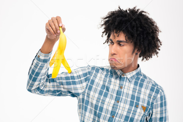 Sad afro american man holding banana skin Stock photo © deandrobot