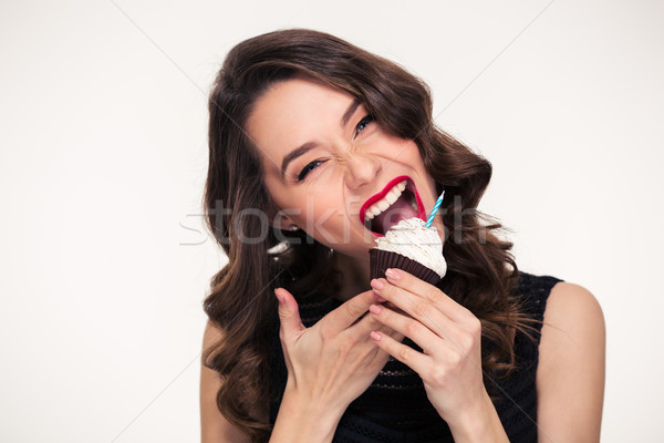 Beautiful curly young woman biting birthday cupcake with candle Stock photo © deandrobot