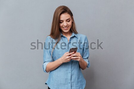 African woman writing message on phone Stock photo © deandrobot