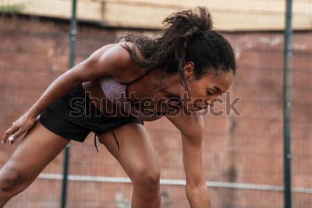 Stock photo: Beautiful young fitness lady sitting in gym